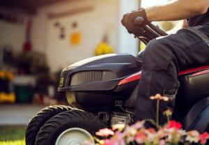close-up of person riding lawn mower
