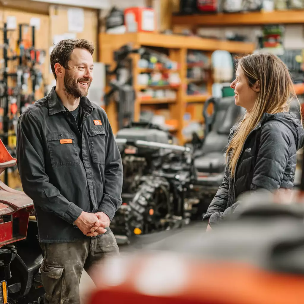 Local outdoor equipment repair technician confidently assisting a customer at Seacoast Power Equipment in North Hampton, NH