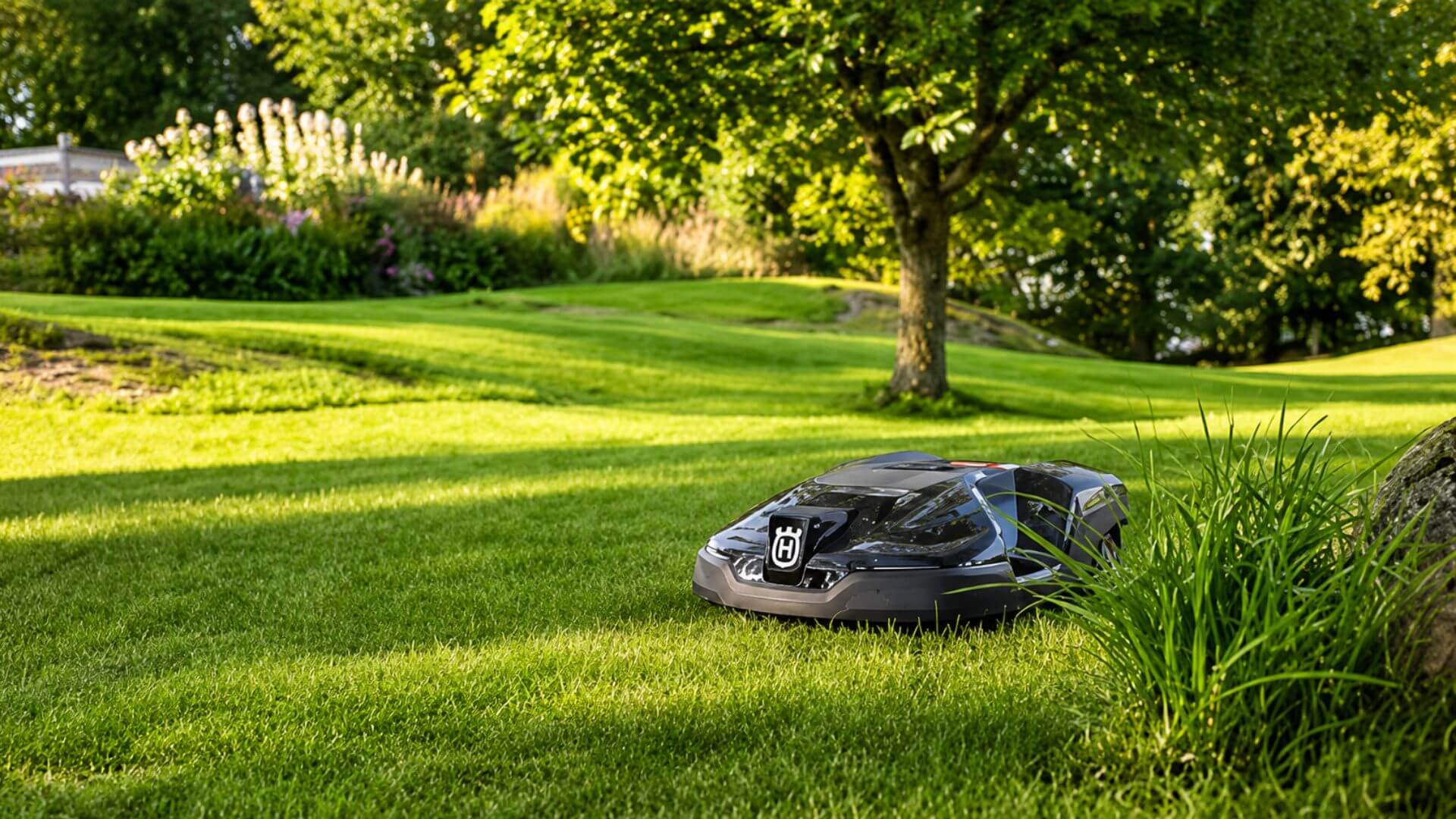 Buy the Husqvarna Automower 420 iQ at Seacoast Power Equipment Husqvarna robotic mower cutting grass on a spacious, well-maintained lawn surrounded by mature trees and landscaping.